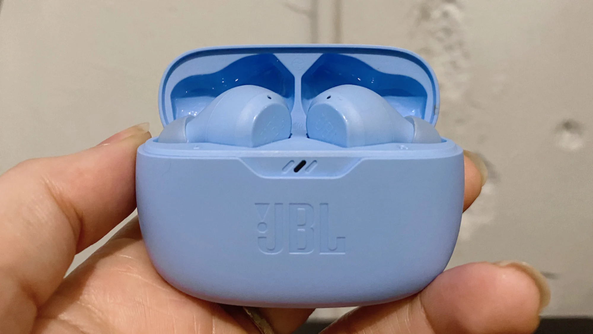 手中的 jbl vivibeam 耳机充电盒特写