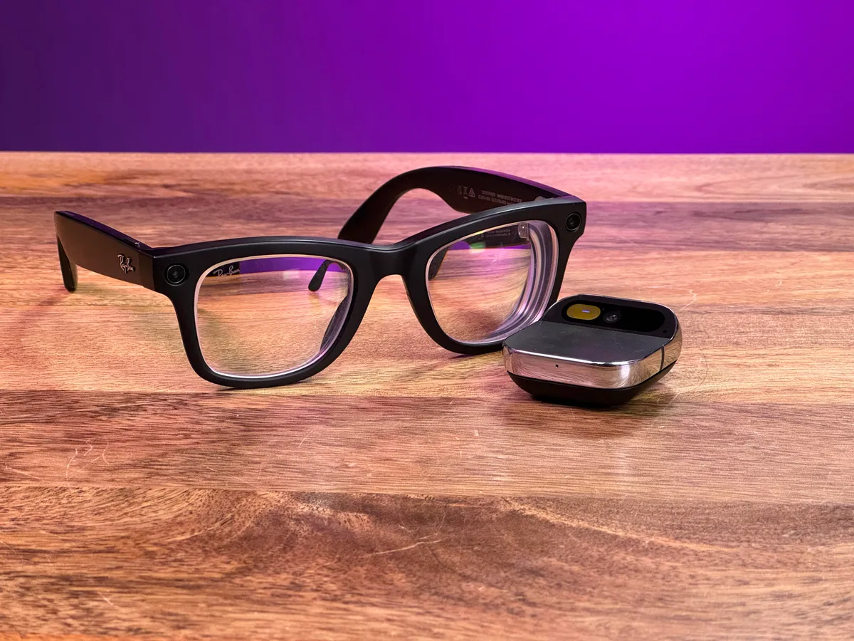 人性化的 AI Pin 和 Meta Ray-Ban 眼镜并排放在木桌上