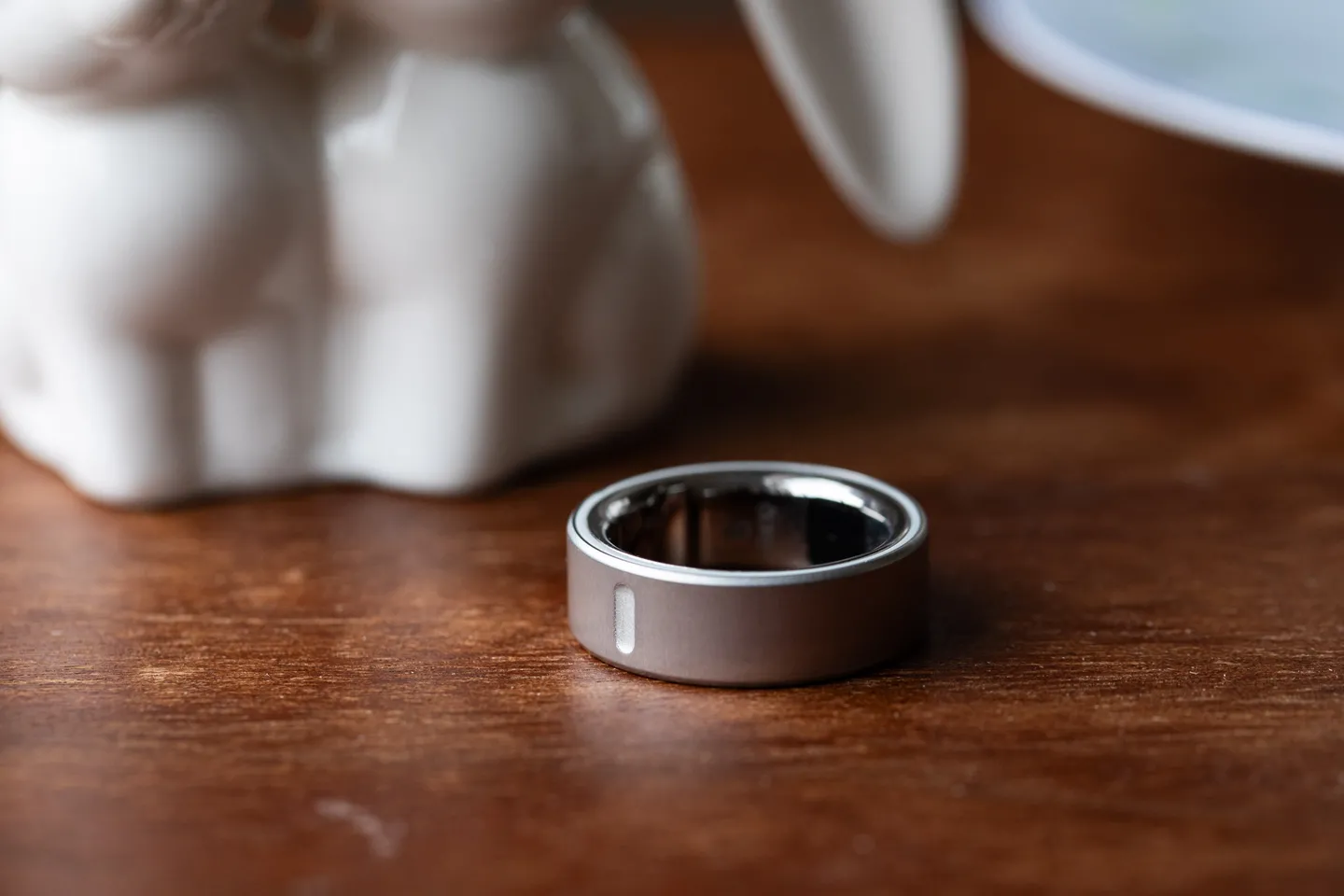 木质表面上的银色 Oura Ring 4 的特写