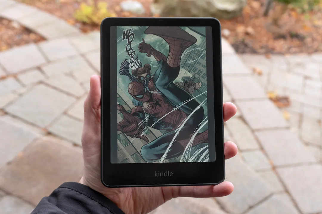 一只手拿着亚马逊 Kindle Colorsoft，屏幕上显示着一幅来自蜘蛛侠漫画的画面