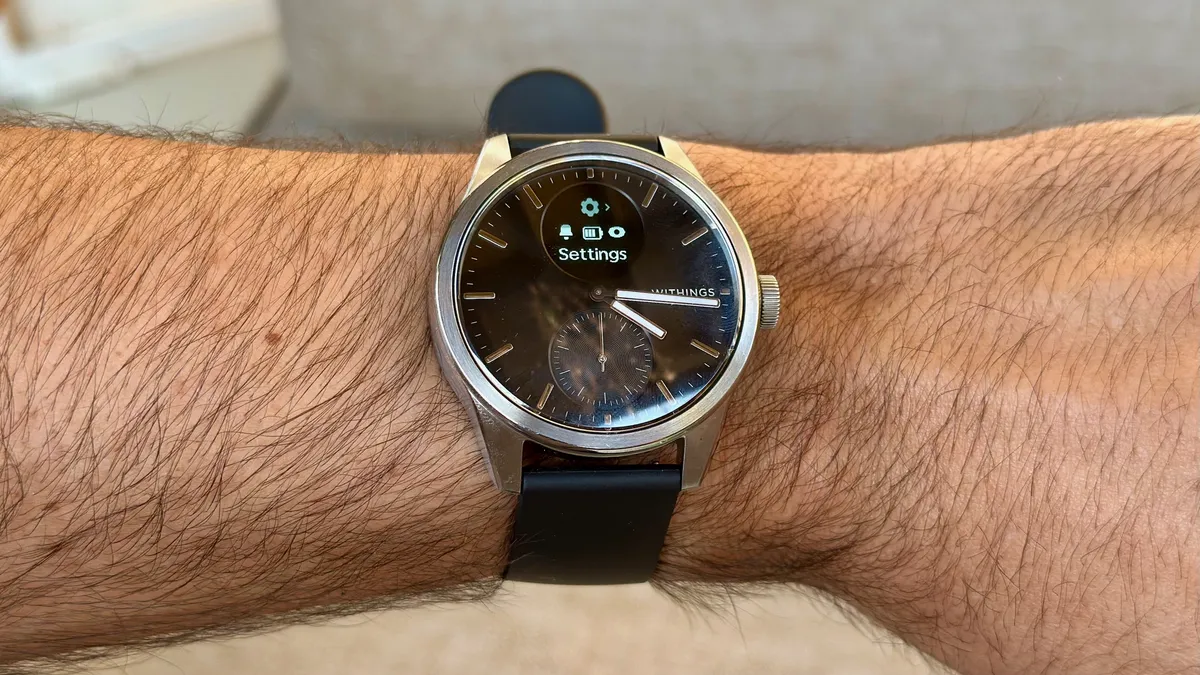 作者手腕上的 Withings ScanWatch 2，小型 OLED 屏幕上显示设置菜单