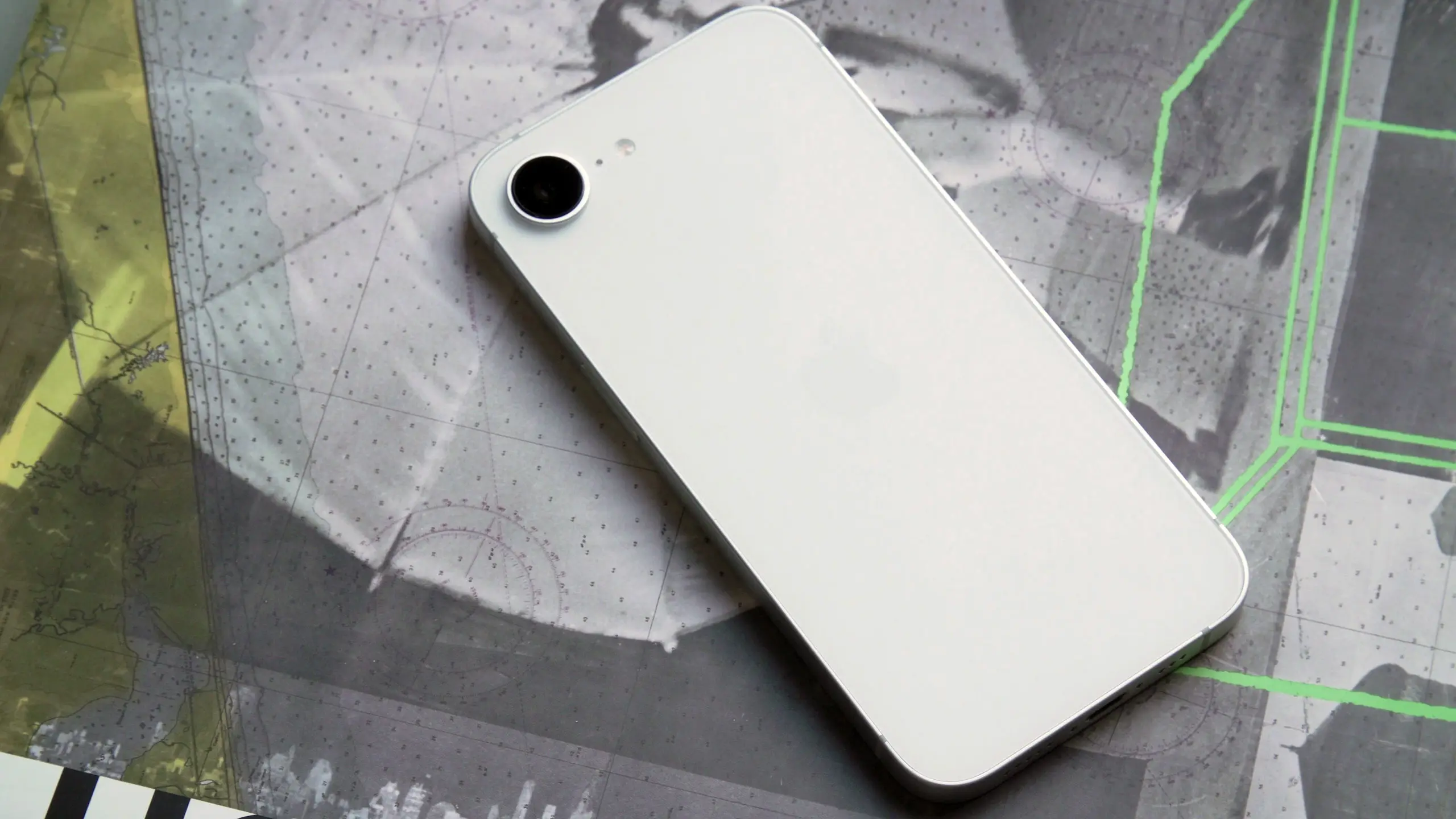 iPhone 16e 背面朝上平放在一个表面上。单个摄像头传感器位于设备左上角。