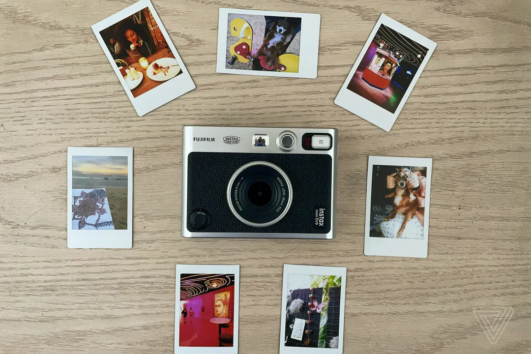 Instax Mini Evo 放在桌子上，周围摆放着它拍摄的照片。