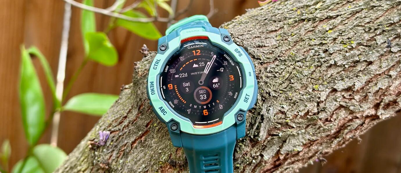 Garmin Instinct 3 50mm AMOLED 放置在一根粗树枝的顶部，表盘上显示着传统表针以及各种小数据字段。