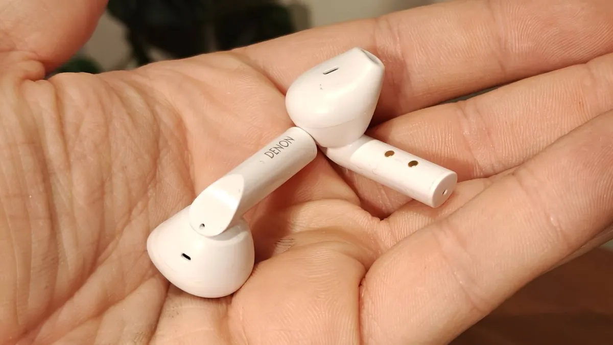 手中的 Denon AH-C500W 耳机。