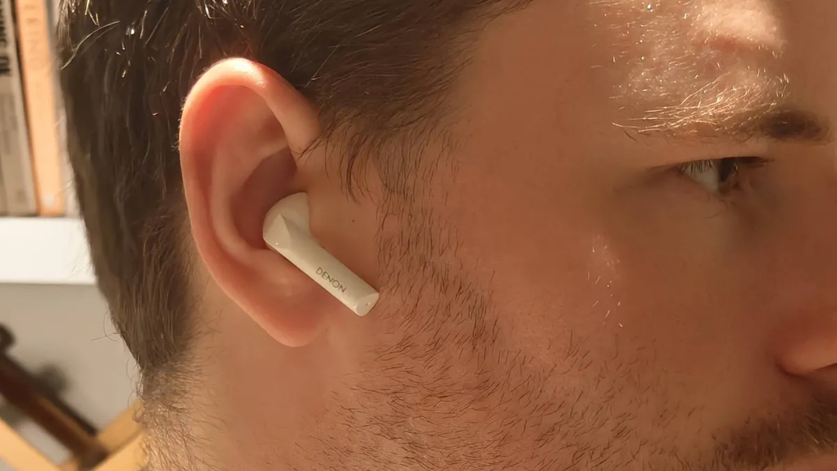 一名男子耳朵里的 Denon AH-C500W。