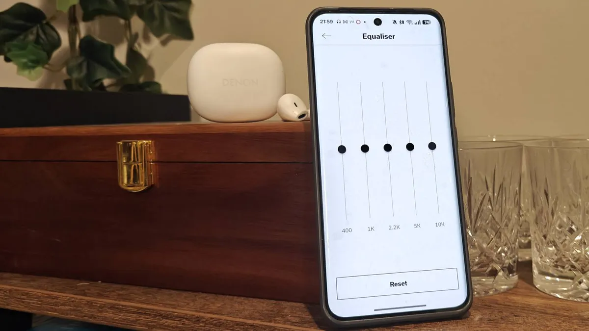 Denon AH-C500W 放在均衡器打开的手机旁边。