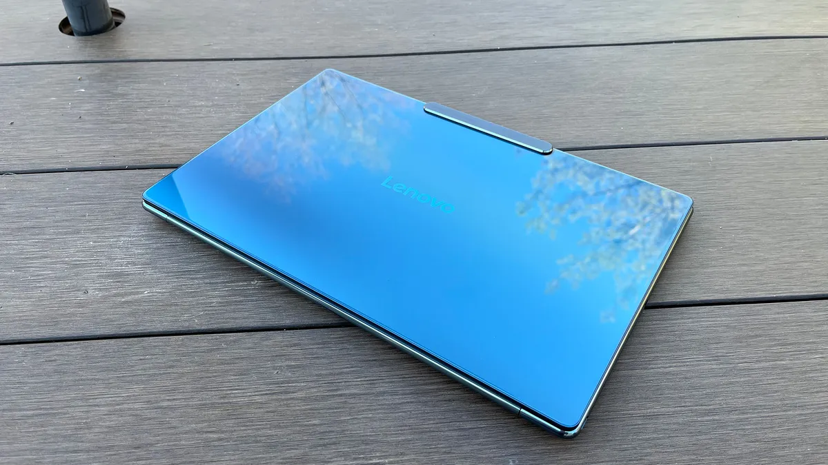 一台联想 Yoga Slim 9i 放在户外的野餐桌上