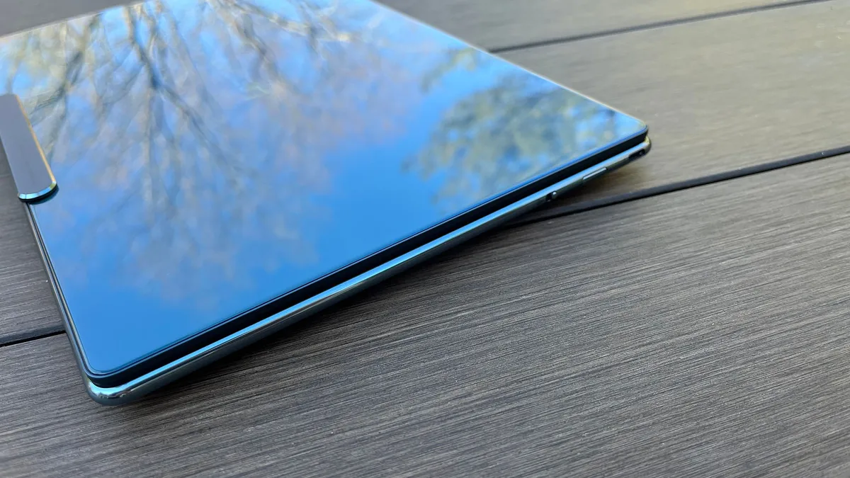 联想 Yoga Slim 9i 放在户外野餐桌上的斜视图