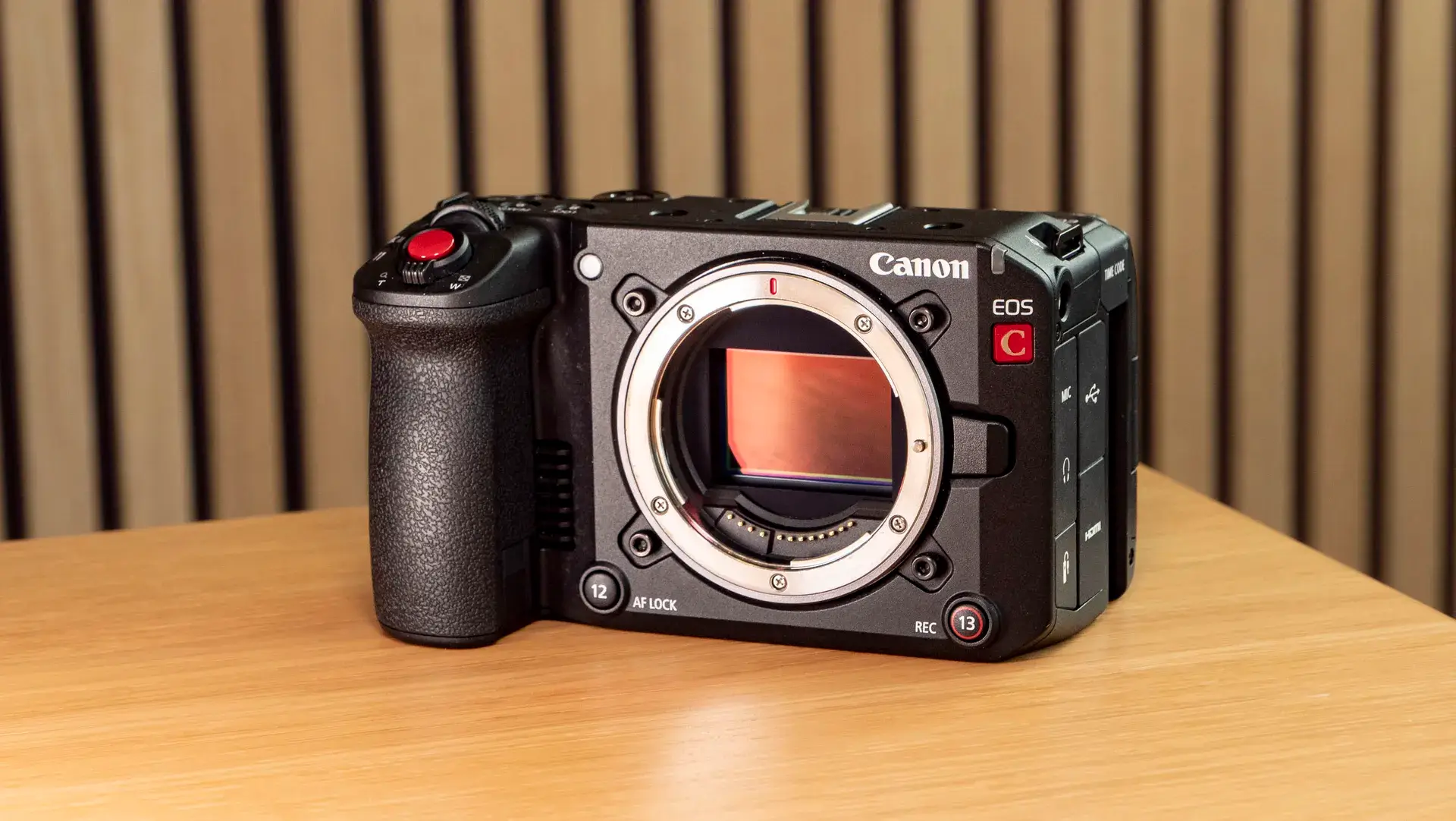 佳能 EOS C50 放在木质表面上，未安装镜头