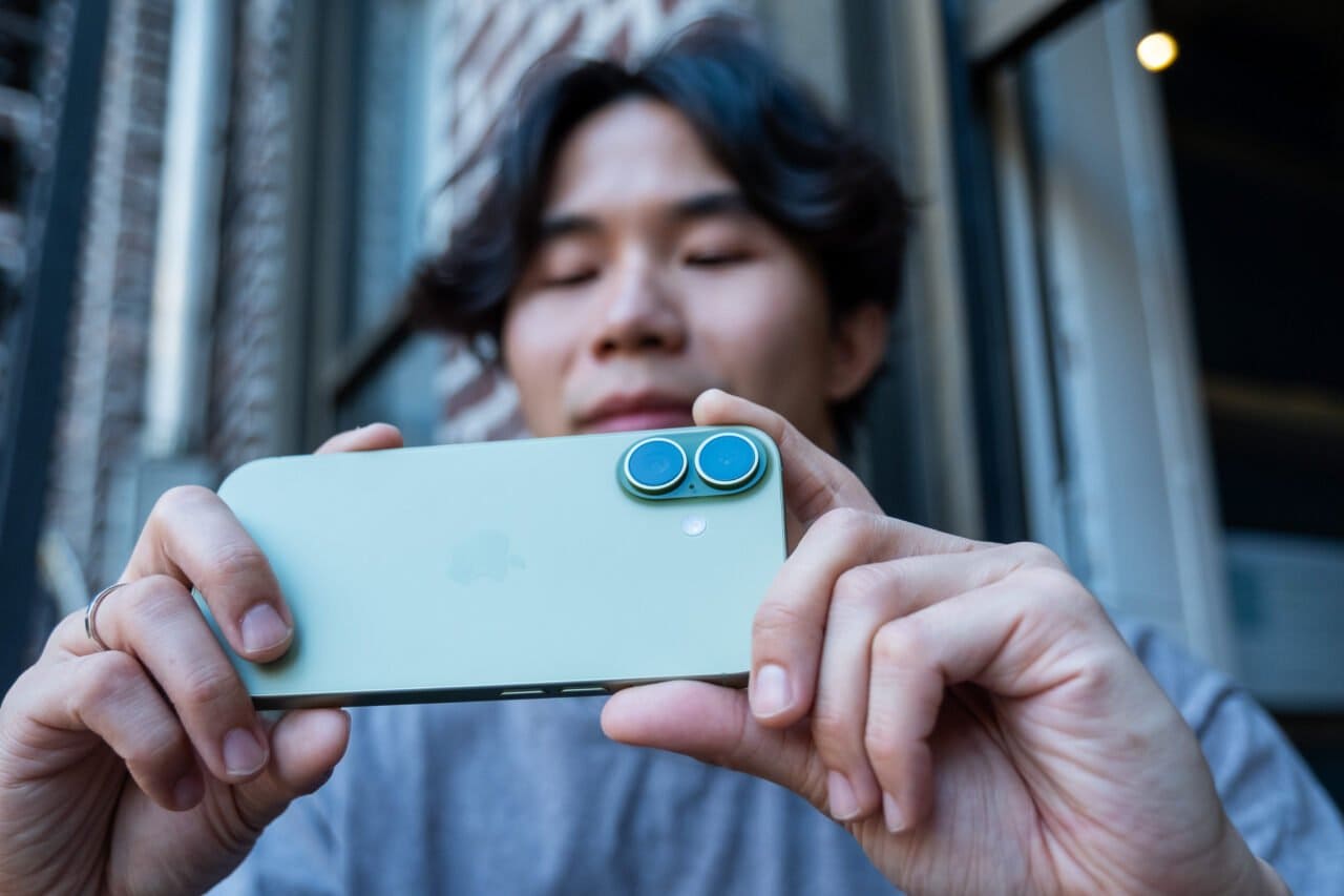 手持灰绿色 iPhone 17 拍照