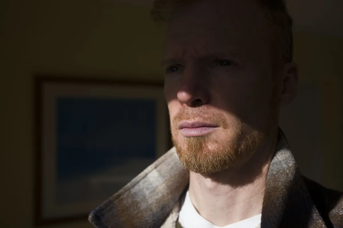 徕卡 M EV1 样张集：男人部分处于阴影中，部分处于窗边的光线中