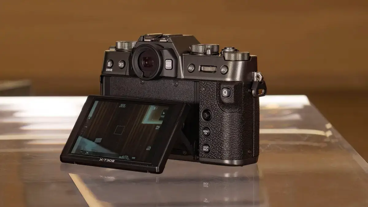 富士 X-T30 III 相机的倾斜屏幕拉出，放在玻璃桌上