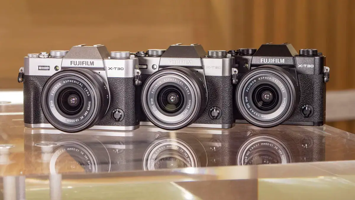 玻璃桌上有三种颜色的富士 X-T30 III 相机