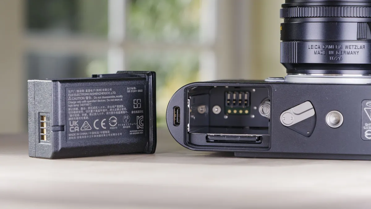 徕卡 M EV1 相机电池盖特写，电池已取出并放置在相机旁边