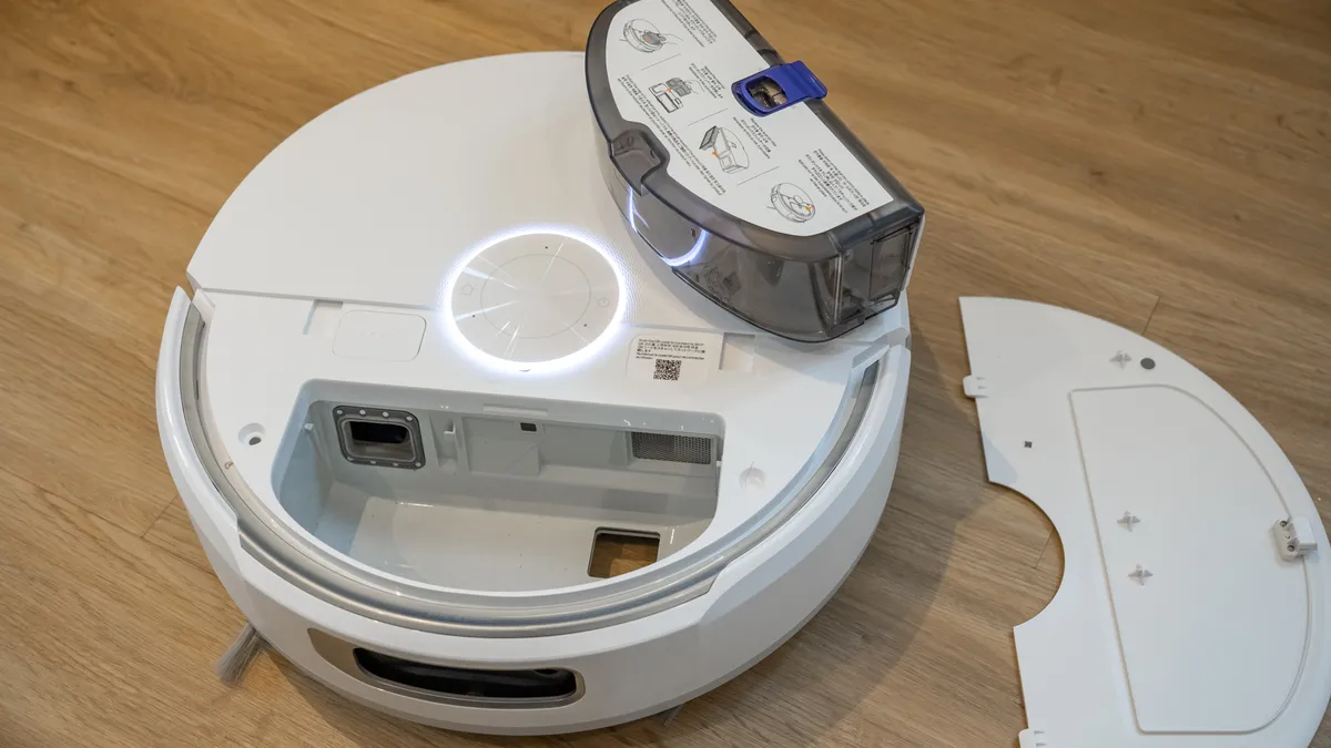 Narwal Flow 机器人吸尘器，内部集尘杯已取出并放置在顶部