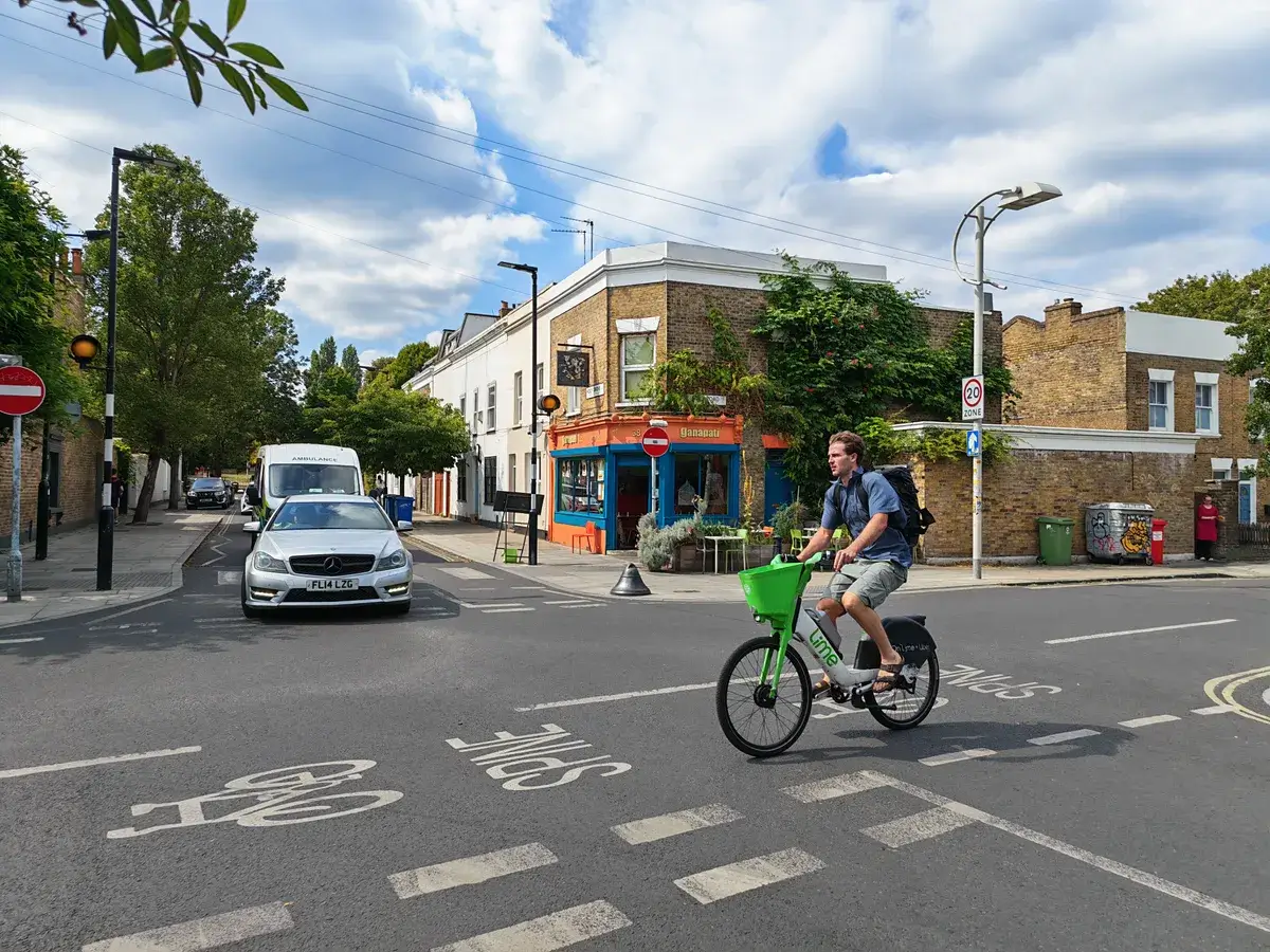 一名男子骑着电动自行车经过一个十字路口