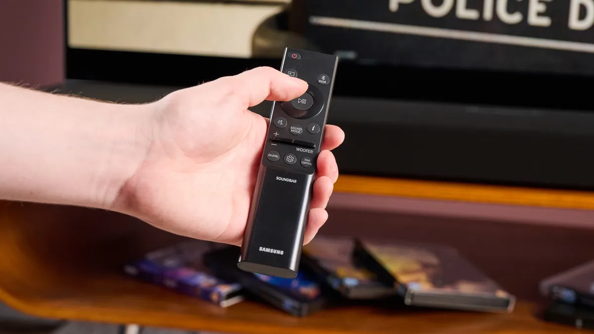 有人正在按下三星 HW-Q800F 遥控器上的按钮