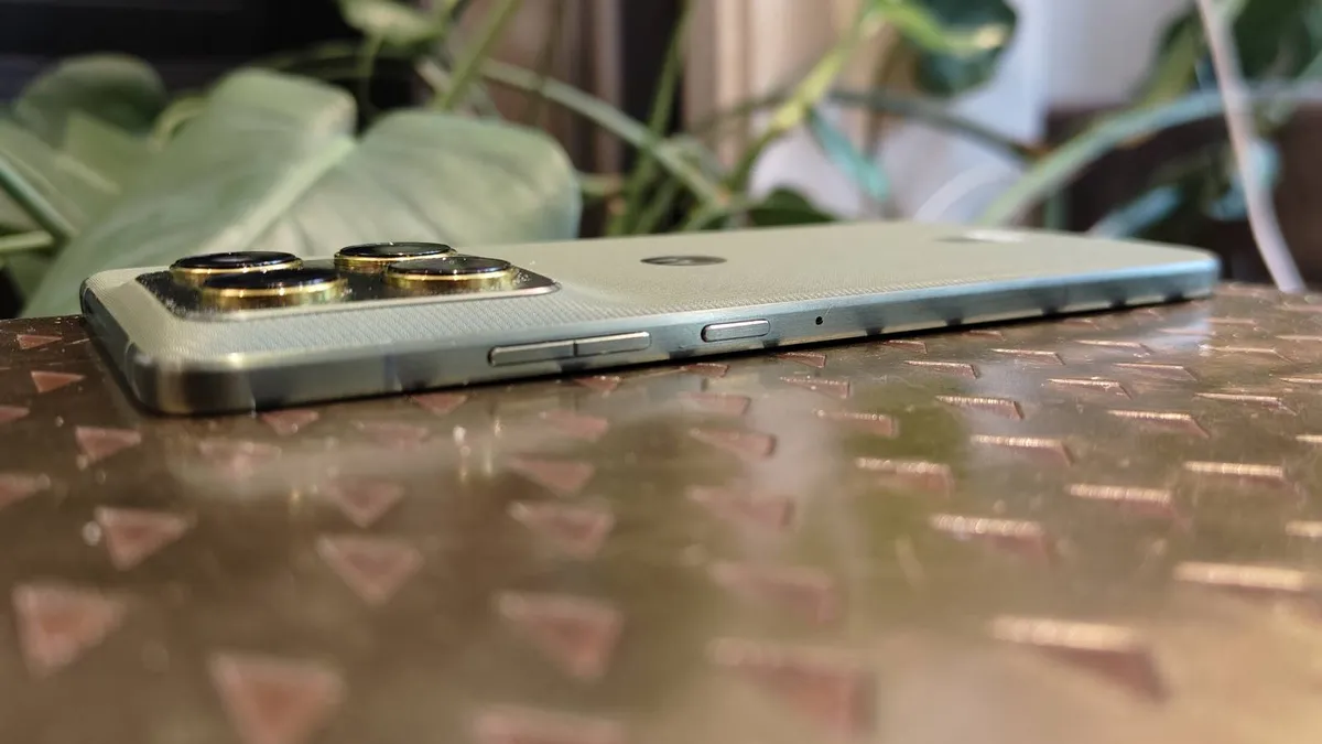 摩托罗拉 Edge 70 手机正面朝下放在棕色的桌子上