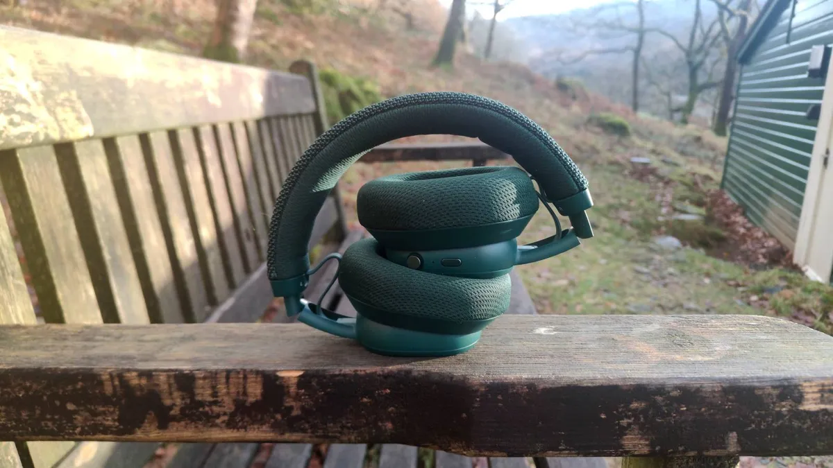 Fairphone Fairbuds XL 2025 折叠起来放在长椅的扶手上 Fairphone Fairbuds XL 2025 折叠起来放在长椅的扶手上