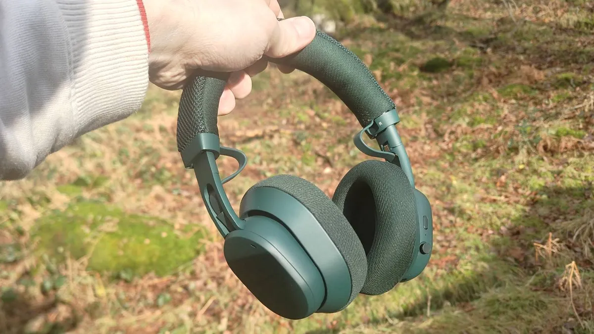 一位男士手中拿着 Fairphone Fairbuds XL 2025 耳机 一位男士手中拿着 Fairphone Fairbuds XL 2025 耳机